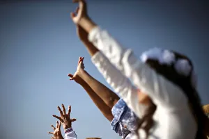 People raise their arms towards the sun to welcome the spring equinox while they are People raise their arms towards the sun to welcome the spring equinox while they are