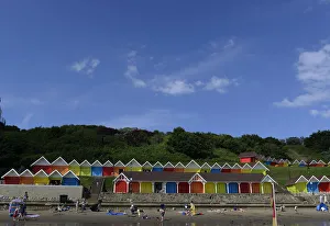 People relax in front of beach huts in the North Bay in Scarborough People relax in front of beach huts in the North Bay in Scarborough
