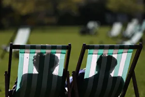 People relax on deck chairs on a warm day in London, Britain People relax on deck chairs on a warm day in London, Britain