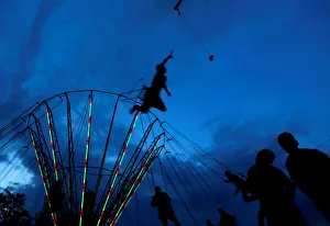 People ride on a swing carousel as part of the traditional celebration of Saint George's People ride on a swing carousel as part of the traditional celebration of Saint George's