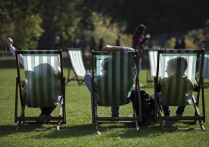 People are silhouetted against their deck chairs as they pose for a selfie photograph People are silhouetted against their deck chairs as they pose for a selfie photograph