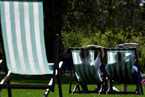 People are silhouetted against the farbric of deckchairs as they enjoy the sunshine in St People are silhouetted against the farbric of deckchairs as they enjoy the sunshine in St