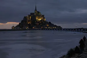 People sit on an embankment as the incoming tide surrounds the Mont Saint-Michel 11th People sit on an embankment as the incoming tide surrounds the Mont Saint-Michel 11th