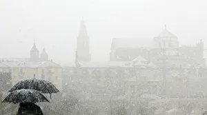 People stand with umbrellas in the snow, in Cordoba People stand with umbrellas in the snow, in Cordoba