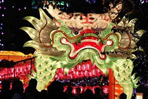 People walk besides a dragon-shaped lantern on display during Lantern Festival celebrations People walk besides a dragon-shaped lantern on display during Lantern Festival celebrations