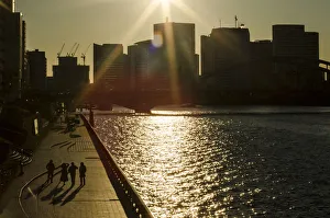 People walk along embankment of Sumida River on sunny winter day during New Year holidays People walk along embankment of Sumida River on sunny winter day during New Year holidays