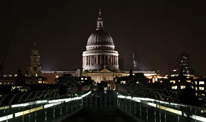 People walk on the Millennium Bridge with St Pauls Cathedral in the background in London People walk on the Millennium Bridge with St Pauls Cathedral in the background in London