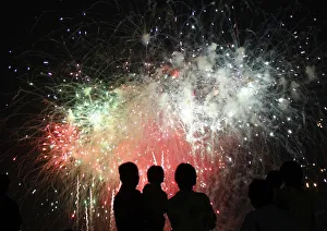 People watch fireworks explode during the Chofu city fireworks festival in Kawasaki People watch fireworks explode during the Chofu city fireworks festival in Kawasaki