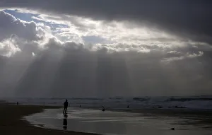 A person stands on the shores of the Mediterranean Sea on a stormy day at Nitzanim beach A person stands on the shores of the Mediterranean Sea on a stormy day at Nitzanim beach