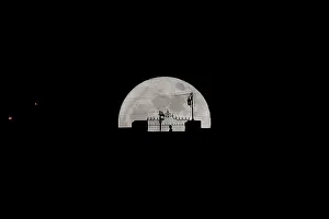 A person walks along the Puente Nuevo (New Bridge) as it is silhouetted against the A person walks along the Puente Nuevo (New Bridge) as it is silhouetted against the
