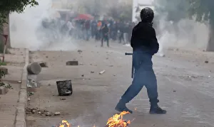 Police officers fire tear gas to break up a protest during demonstrations against rising Police officers fire tear gas to break up a protest during demonstrations against rising