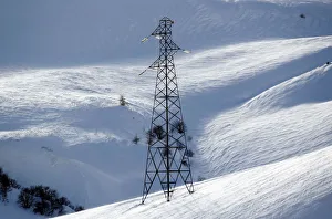 Pylon of high-tension electricity power lines is pictured on snow-covered mountain in Pylon of high-tension electricity power lines is pictured on snow-covered mountain in