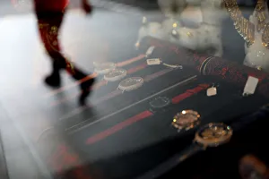 The reflection of a man walking is seen in the window of a shop selling watches in The reflection of a man walking is seen in the window of a shop selling watches in