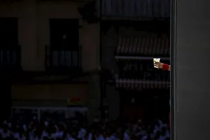 A reveller with a red scarf tied to her wrist holds a drink during the start of the San A reveller with a red scarf tied to her wrist holds a drink during the start of the San