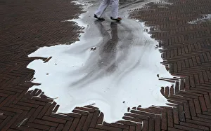 A reveller walks across a puddle of cleaning water on the fifth day of the San Fermin A reveller walks across a puddle of cleaning water on the fifth day of the San Fermin