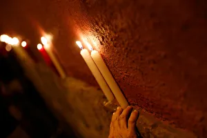 Revellers place candles on a wall after the closing ceremony of the San Fermin festival Revellers place candles on a wall after the closing ceremony of the San Fermin festival