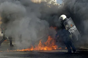 Riot policemen walk by fires caused by petrol bombs during strike in central Athens Riot policemen walk by fires caused by petrol bombs during strike in central Athens