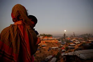 A Rohingya refugee looks at the full moon with a child in tow at Balukhali refugee camp A Rohingya refugee looks at the full moon with a child in tow at Balukhali refugee camp