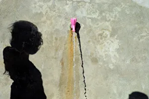 The shadow of an internally displaced girl who fled Raqqa is cast at the water point The shadow of an internally displaced girl who fled Raqqa is cast at the water point