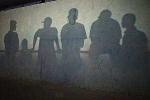 Dakar Collection: Shadows are cast on the wall of a stadium as people watch a traditional wrestling