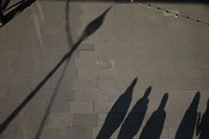 The shadows of pedestrians are cast on the pavement as they walk along the South Bank The shadows of pedestrians are cast on the pavement as they walk along the South Bank