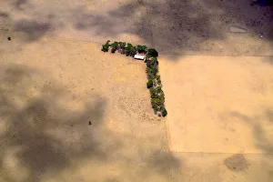 A shed and line of trees can be seen in a paddock on a farm located on the outskirts of A shed and line of trees can be seen in a paddock on a farm located on the outskirts of