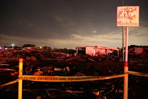A sign reading No alcoholic beverages is seen next to flattened houses after an A sign reading No alcoholic beverages is seen next to flattened houses after an