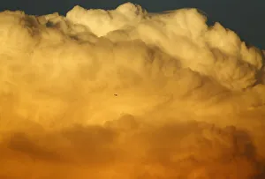A small aircraft flies past a large emerging thunderstorm during sunset near Encinitas A small aircraft flies past a large emerging thunderstorm during sunset near Encinitas