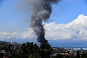 Smoke billows from a burning building in Marinaut village as government troops continue Smoke billows from a burning building in Marinaut village as government troops continue