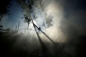 Smoke is seen as a Palestinian man inspects a militant target that was hit in an Israeli Smoke is seen as a Palestinian man inspects a militant target that was hit in an Israeli
