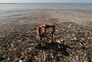 A soldier pauses while cleaning plastic and other debris on the shores of Montesinos A soldier pauses while cleaning plastic and other debris on the shores of Montesinos