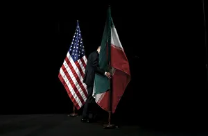 A staff member removes the Iranian flag from the stage after a group picture with foreign A staff member removes the Iranian flag from the stage after a group picture with foreign