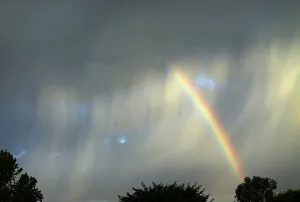 A summer rainbow breaks through an isolated and quickly moving thunderstorm as it passes A summer rainbow breaks through an isolated and quickly moving thunderstorm as it passes