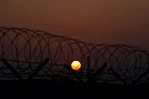 The sun rises over a barbed-wire fence at a checkpoint on the Grand Unification Bridge in The sun rises over a barbed-wire fence at a checkpoint on the Grand Unification Bridge in