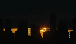 The sun rises behind the skyline of Manhattan as it is partially eclipsed by the moon The sun rises behind the skyline of Manhattan as it is partially eclipsed by the moon