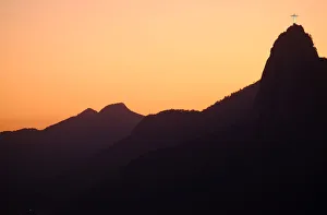 The sun sets behind Christ the Redeemer statue on Corcovado mountain in Rio de Janeiro The sun sets behind Christ the Redeemer statue on Corcovado mountain in Rio de Janeiro