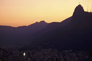 The sun sets behind Christ the Redeemer statue on Corcovado mountain in Rio de Janeiro The sun sets behind Christ the Redeemer statue on Corcovado mountain in Rio de Janeiro