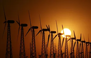 The sun sets behind power-generating turbines of a local wind farm in Crimea The sun sets behind power-generating turbines of a local wind farm in Crimea