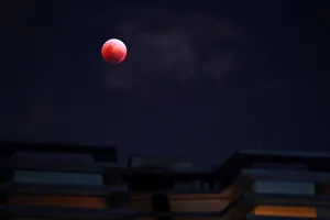 A Super Blue Blood Moon rises over an apartment block during a lunar eclipse in A Super Blue Blood Moon rises over an apartment block during a lunar eclipse in