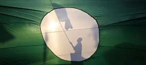A supporter of opposition PAS is silhouetted on its giant flag as he campaigns on a A supporter of opposition PAS is silhouetted on its giant flag as he campaigns on a