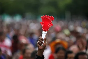 A supporter of the opposition Puea Thai Party holds up a plastic clapper in Si Sa Ket A supporter of the opposition Puea Thai Party holds up a plastic clapper in Si Sa Ket