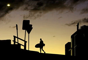 Images Dated 16th June 2005: A surfer crosses the road with his board at sunset above Sydneys Bondi Beach