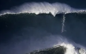 A surfer drops in on a large wave at Praia do Norte, in Nazare A surfer drops in on a large wave at Praia do Norte, in Nazare