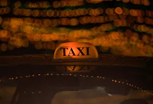 A taxi drives through the street decorated with lights ahead of Tihar festival A taxi drives through the street decorated with lights ahead of Tihar festival