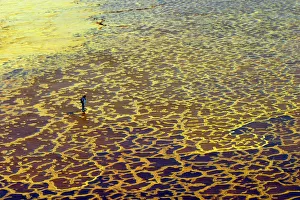 A tourist visits yellow sulphur and mineral salt formations created by upwelling springs A tourist visits yellow sulphur and mineral salt formations created by upwelling springs