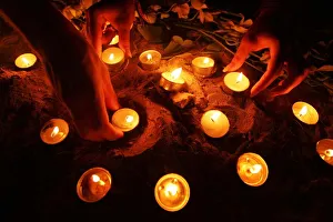 Tourists arrange oil lamps during candle light vigil ceremony on Thai island of Phi Phi Tourists arrange oil lamps during candle light vigil ceremony on Thai island of Phi Phi