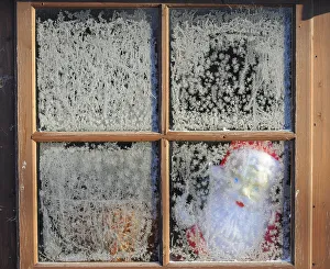 A toy Santa Claus is seen through the frosted window of a garden shed near Boroughbridge A toy Santa Claus is seen through the frosted window of a garden shed near Boroughbridge