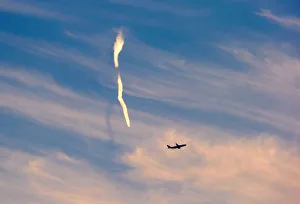 The trail of an aeroplane can be seen amongst clouds and above a plane after it took The trail of an aeroplane can be seen amongst clouds and above a plane after it took