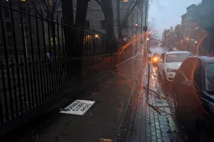 Tree limbs and debris are scattered on the sidewalk as heavy rain Tree limbs and debris are scattered on the sidewalk as heavy rain