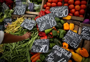 A vegetable seller grabs a handful of indian beans at a street market, in Buenos Aires A vegetable seller grabs a handful of indian beans at a street market, in Buenos Aires